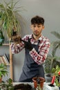 Spring houseplant care. Man repotting houseplants into new pots at home. Gardener transplant plant and recording video Royalty Free Stock Photo