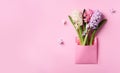 Spring hyacinth flowers in pink postal envelope over punchy pastel background with copy space. Top view, flat lay. Banner. Spring