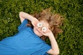 Spring kid. Happy child enjoying on grass field and dreaming. Funny little boy with daisy in eyes. Royalty Free Stock Photo