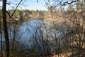 spring on the lake. Clear sky with light clouds and trees are reflected in the water