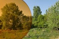 Spring lakeside shore landscape with broadleaf trees as seen normally and through orange tinted sport eyeglass lenses.