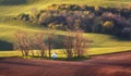 Spring landscape with amazing chapel in green fields at sunset