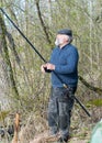 Spring landscape with an angler, an angler inspecting fishing rods, lake shore, spring Royalty Free Stock Photo