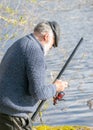 Spring landscape with an angler, an angler inspecting fishing rods, lake shore, spring Royalty Free Stock Photo