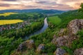 Spring landscape with blooming fields, green meadows and a meandering river in a valley under rocks. Royalty Free Stock Photo