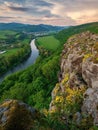 Spring landscape with blooming fields, green meadows and a meandering river in a valley under rocks. Royalty Free Stock Photo