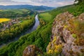 Spring landscape with blooming fields, green meadows and a meandering river in a valley under rocks. Royalty Free Stock Photo