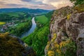 Spring landscape with blooming fields, green meadows and a meandering river in a valley under rocks. Royalty Free Stock Photo