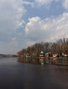 Spring landscape with colorful authentic houses on the river bank near the forest. Amazingly sky above the village