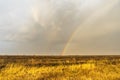 Spring landscape with double rainbow over burned field after thunderstorm. Beautiful natural background