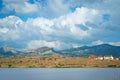 Spring landscape with houses, mountains and clouds in sky