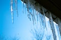 Spring landscape with ice icicles hanging from roof of house. Royalty Free Stock Photo