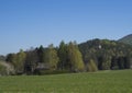 Spring landscape with view on village Marenice in Lusitian mountains with small chapel on hill, lush green grass meadow Royalty Free Stock Photo