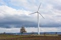 Spring landscape with wind turbine against a cloudy sky Royalty Free Stock Photo