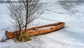 spring landscape with a wooden boat frozen in ice, abandoned boats on the shore of the lake, late winter, spring in nature Royalty Free Stock Photo