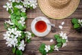 Spring layout with branches of a flowering apple tree, a cup of tea and a straw hat Royalty Free Stock Photo