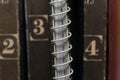 A spring-loaded notebook among old brown books Royalty Free Stock Photo