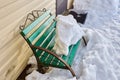 Snow-covered bench thaws in spring in countryside. Royalty Free Stock Photo
