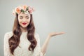 Spring Model Woman Showing Empty Open Hand with Copy Space. Pretty Girl with Clear Skin, Curly Hair, Makeup and Flowers.