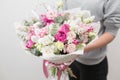 Spring mood. beautiful luxury bouquet of mixed flowers in woman hand. the work of the florist at a flower shop. Horizontal photo