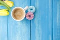 Spring morning, fragrant coffee and tulips of yellow and pink color. Donuttsy copies. Blue wooden background, place for text and