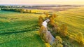 Spring morning landscape. Calm river in blooming meadows. Aerial rural view from above. Agricultural yellow green colza fields. Royalty Free Stock Photo