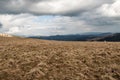 Spring mountain meadow with hills on the background and blue sky with clouds in Carpathians Royalty Free Stock Photo