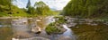 Spring mountain river panorama. Creek water flowing through stones and rocks. Green rural landscape Royalty Free Stock Photo