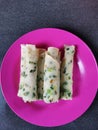 Spring onion roll pancakes on a pink plate
