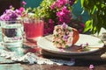 Spring outdoor table with floral aesthetics cupcake, compote and glass of water. Spring lilac flowers outdoor on sunny