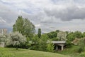 Spring panorama of a part of residential district neighborhood along a lake with green trees, flowering willow, shrubs and flowers