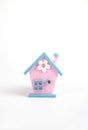 Spring pink and blue house with white flower made of felt on white background Royalty Free Stock Photo