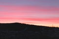 Spring pink and blue sunset over the forest and village. Pink and blue clouds at sunrise. A gentle dawn paints a dark forest and Royalty Free Stock Photo