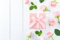 Spring pink flowers and gift box on white wooden background