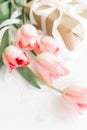 Spring. Pink tulips with ribbon and gift box on white background. Stylish soft vertical image of spring flowers. Happy womens day Royalty Free Stock Photo