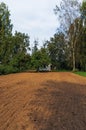 Spring ploughed field near small house. Royalty Free Stock Photo