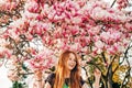 Spring portrait of adorable red-haired preteen kid girl with magnolia flowers Royalty Free Stock Photo