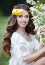 Spring portrait of a beautiful woman in a wreath of flowers