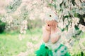 Spring portrait of cute baby girl in green skirt enjoying outdoor walk in blooming garden Royalty Free Stock Photo