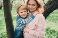 Spring portrait of happy pregnant mother enjoying warm day with child son