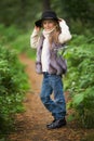 Spring portrait of a little girl.Sweet girl with big brown eyes in a black hat and a fur vest. Royalty Free Stock Photo