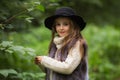 Spring portrait of a little girl.Sweet girl with big brown eyes in a black hat and a fur vest. Royalty Free Stock Photo