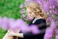 Spring portrait of thoughtful blonde woman, violet flowers