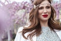 Spring portrait woman brunette hair perl decoration perfect skin care makeup cosmetic red lipstick blooming trees perfume Royalty Free Stock Photo