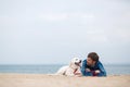 Spring portrait of a young man with a dog on the beach Royalty Free Stock Photo