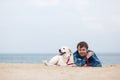 Spring portrait of a young man with a dog on the beach Royalty Free Stock Photo