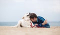 Spring portrait of a young man with a dog on the beach Royalty Free Stock Photo