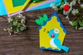 Spring postcard birdhouse with a bird on a wooden table. Handmade. Project of childrens creativity, handicrafts, crafts for kids Royalty Free Stock Photo