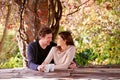 Spring, relax and couple embrace with coffee cups on table in nature, environment and together for romance. Partners
