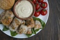 Spring roll with meat and vegetables served on a white dish with sauce. Wooden background